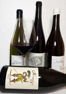 Natalia Zych – sommelierka Ta od Wina – prezentuje cztery różne butelki wina i kieliszek z czerwonym winem podczas degustacji prywatnej